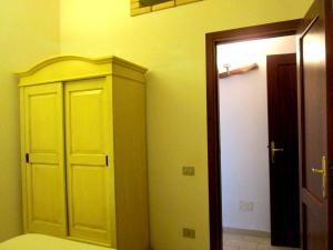 a room with a closet and a door in a room at Sardinia Yellow House in Solanas