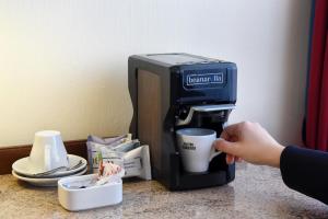 a person is using a blender on a counter at Glärnischhof by TRINITY in Zurich