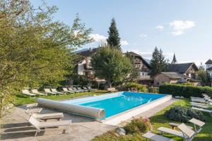 a swimming pool in a yard with lounge chairs at Landhotel Gasthof Zum Löwen in Rodengo