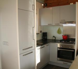 een keuken met witte kasten en een fornuis bij Rekerlanden 154 in Schoorldam