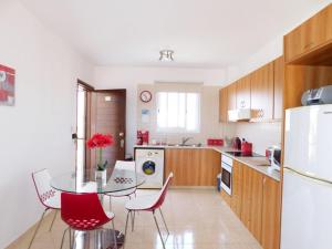 a kitchen with a table and chairs and a refrigerator at Excellent 2 bed Apartment in Mandria
