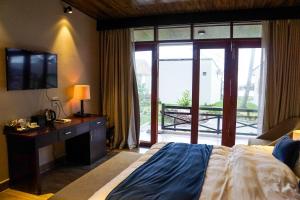 a bedroom with a bed and a television and a balcony at The Pier Phu Quoc Resort in Phu Quoc +69 photos