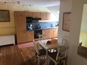 a kitchen with a table and chairs and a dining room at Fewo Zufriedenheit in Sehestedt