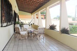 eine Veranda mit Stühlen und einem Tisch darauf in der Unterkunft Hotel Pousada Calhau in São Luís