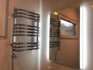 a bathroom with a mirror and a rack of wine glasses at Eden House in Druskininkai