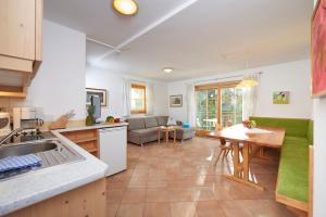 cocina y sala de estar con mesa y sofá en Appartement Hotel Sonneck en Königsleiten