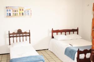 two beds in a room with white walls at Hotel Pousada Calhau in São Luís +34 photos