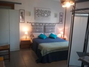 una camera da letto con letto, cuscini blu e specchio di Le Luberon Lou Mas Li Pitchoun a Gordes