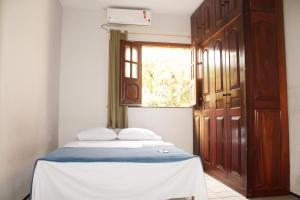 a bedroom with a bed and a window and a door at Hotel Pousada Calhau in São Luís