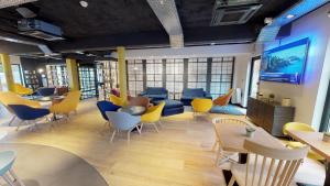 a waiting room with chairs and a couch and tables at Campanile Fontainebleau in Fontainebleau