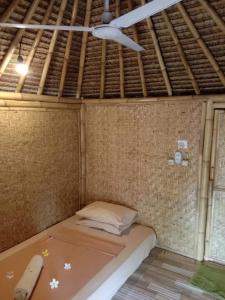 Cama en habitación con ventilador de techo en Gili Kampoeng en Gili Trawangan