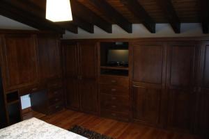 a living room with wooden cabinets and a television at La Campanona in Abamia