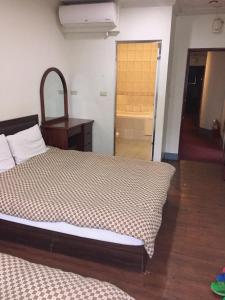 1 dormitorio con 1 cama y puerta al baño en Xiang Dou Hotel en Jiaoxi