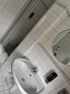 a bathroom with a white sink and a mirror at Hotel Kaiserhof in Munster im Heidekreis +120 photos