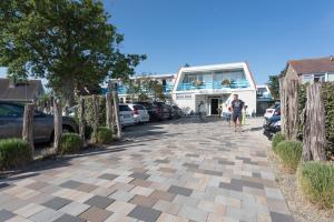 a man walking down a sidewalk in front of a building at Hotel Kijkduin in Domburg