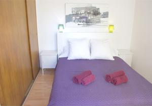Una cama con dos zapatillas rojas encima. en Apartment carrer d'Olesa, en Barcelona