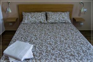 un letto con coperta e cuscini bianchi e neri di B&B Sicily a Porto Empedocle