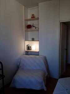 a small room with a bed and a shelf at Cannaregio apartment in Venice