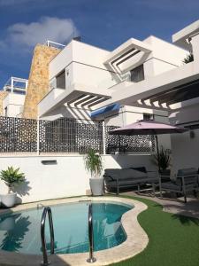 a house with a swimming pool in front of it at Villa Bianco in Orihuela Costa