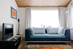 un soggiorno con divano blu e TV di holiday cottage 'FLOW' a Bergen