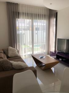 a living room with a couch and a tv and a table at Villa Bianco in Orihuela Costa