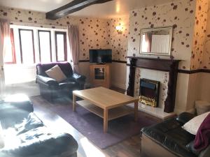 a living room with a couch and a fireplace at The Cottage, cosy 2 bedroom pet friendly perfect for contractors free secure parking,CCTV in Leeds