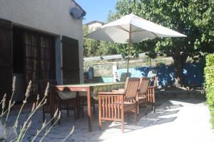 ein Tisch und Stühle mit einem Sonnenschirm auf einer Terrasse in der Unterkunft Maison-Limoux Chambre D'Hote Limoux 11300 in Limoux