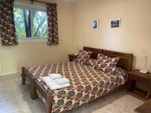 een slaapkamer met een bed en een raam bij Hostel Los Pioneros in El Calafate