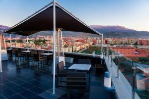 een dakterras met tafels en stoelen en uitzicht op de stad bij Hotel Golden Flora in Beni Mellal