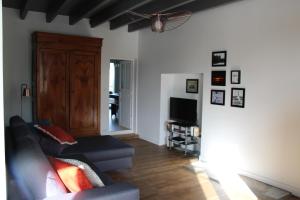 ein Wohnzimmer mit einem Sofa und einem TV in der Unterkunft Chez Maria in Cherrueix