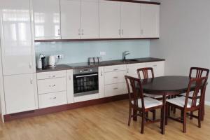 a kitchen with white cabinets and a table and chairs at Riga Central Park Apartment in Riga