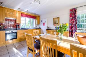 a kitchen with a wooden table and chairs at Lake Cottage in Thorpeness