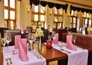 a dining room with a table with pink napkins at Landhaus Am Grün in Kühlungsborn