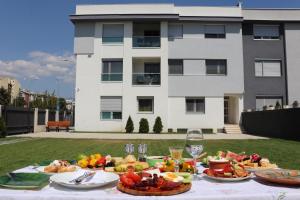 a table with a bunch of food on it with a building at Foxxy Luxury Apartments in Skopje