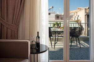 Cette chambre dispose d'un balcon avec une table et des bouteilles de vin. dans l'établissement Acropolis View Penthouse, à Athènes