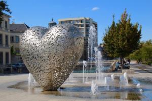 une statue de cœur métallique dans une fontaine d'une ville dans l'établissement Logis Hôtel du Cirque Troyes centre historique, à Troyes