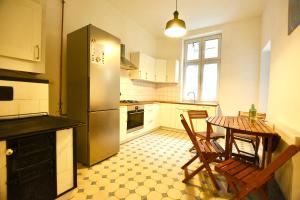 a kitchen with a table and chairs and a refrigerator at Apartament pod Zamkiem 8os. in Bielsko-Biała