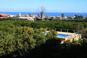 a house with a swimming pool on a hill at Giardino Arancio in Giarre