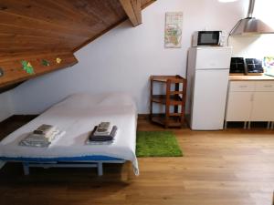 a room with a bed and a kitchen with a refrigerator at Cozy Central in Ponta Delgada