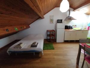 a room with a bed and a kitchen with a refrigerator at Cozy Central in Ponta Delgada