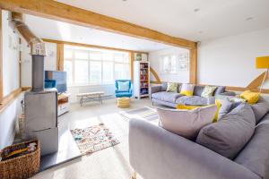 a living room with a couch and a stove at Meare House in Thorpeness