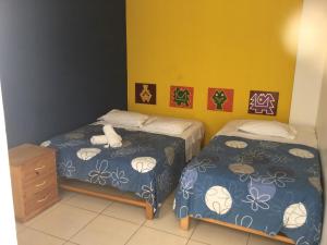 two beds in a room with blue walls at Paracas Backpackers House in Paracas