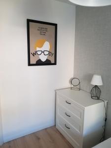 sypialnia z komodą i zdjęciem na ścianie w obiekcie Apartament Monika w Kłodzku