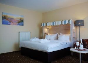 a hotel room with a large bed with white pillows at Landhaus Am Grün in Kühlungsborn