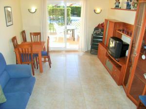 a living room with a blue couch and a tv at TARRACO 20 (BOLLERIA) in L'Estartit