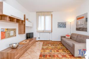 uma sala de estar com um sofá e uma televisão em DesenzanoLoft Enjoy em Desenzano del Garda