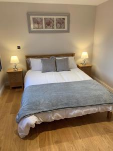 Un dormitorio con una cama grande con dos lámparas. en Chestnut-Lodge is rural, secluded, private with Hot Tub, en Maidstone