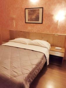 un letto in una camera da letto con una foto sul muro di Hotel Ariosto centro storico a Reggio Emilia