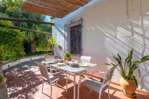 une terrasse avec une table, des chaises et une piscine dans l'établissement Cortijo el Azahar, à Órgiva