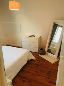 - une chambre avec un lit, une commode et un miroir dans l'établissement Charmant 2 pièces - Centre ville de Melun, à Melun